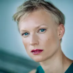 Portret Lise Risom Olsen z błękitnymi oczami i krótkimi blond włosami.