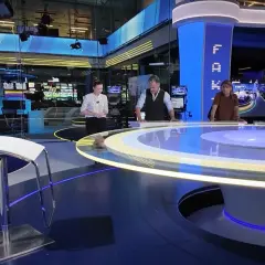 Trzy osoby stoją przy okrągłym stole w nowoczesnym tvn studio sękocin. W tle monitory i sprzęt.