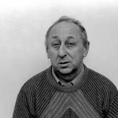 Portret Tadeusza Wojtycha w swetrze z geometrycznym wzorem. Jego twarz jest zmarszczona, a spojrzenie skierowane prosto w obiektyw.