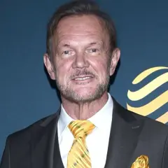 Cezary Pazura w garniturze, z żółtym krawatem i poszetką. Ciekawe, ile zarabia Cezary Pazura, patrząc na jego styl.