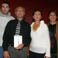 Szymon Sipowicz z książką "Kamil Sipowicz" w ręku, obok niego stoją inne osoby.