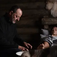 Jean Reno w "Cold Blood Legacy" obsada: mężczyzna pochyla się nad ranną kobietą w chatce.