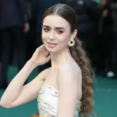 Lily Collins, gwiazda serialu "Emily w Paryżu", w kwiecistej sukni i z błyszczącymi kolczykami.