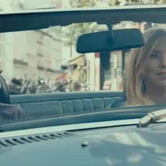 Dwie kobiety w kabriolecie, uśmiechnięte, jadą ulicą. Scena z filmu "Ostatnie lato".