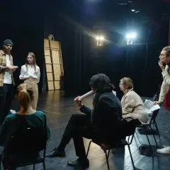 Aktorzy na próbie dyskutują o scenariuszu, zastanawiając się, ile zarabia aktor za dzień zdjęciowy.