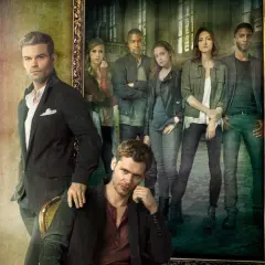 Grupowe zdjęcie obsady "The Originals" w stylizowanych strojach. W pierwszym planie siedzi Klaus, a za nim stoi Elijah. W tle, w ramie obrazu, widać pozostałych członków rodziny.