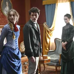 Matylda serial TVP: młoda kobieta w niebieskiej sukni, mężczyzna w marynarce i kobieta w zielonej kreacji stoją w bogato zdobionym pokoju.
