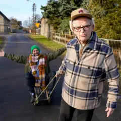 Starszy pan ciągnie młodszego na sankach. To lekcja rzeczy, których nie nauczył mnie ojciec: zabawy i beztroski.