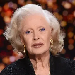 Portret Beaty Tyszkiewicz z siwymi włosami, niebieskimi cieniami do powiek i elegancką biżuterią.