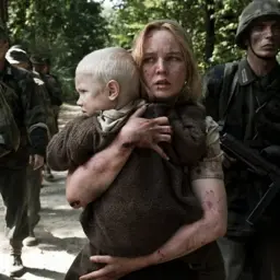 Kobieta z dzieckiem, otoczona żołnierzami, w stylu Smarzowskiego. Scena wojenna, pełna napięcia i bólu.