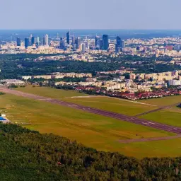 Widok na lotnisko na Bemowie z panoramą Warszawy w tle.