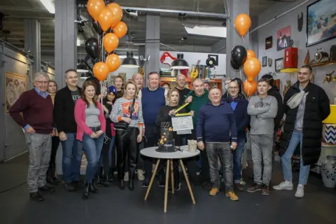 Aktorzy lombardu "Życie pod zastaw" świętują 500. odcinek. Grupa ludzi pozuje do zdjęcia z tortem i tabliczką klapsową.