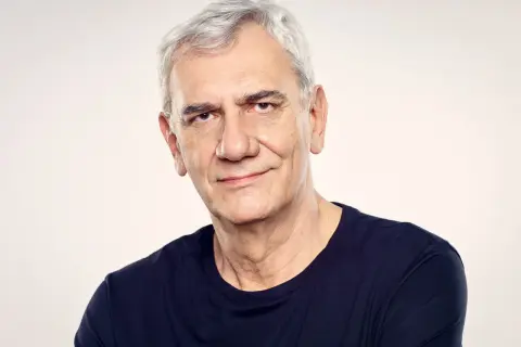 Wiktor Zborowski, z siwymi włosami i w granatowej koszulce, patrzy z uśmiechem w obiektyw.