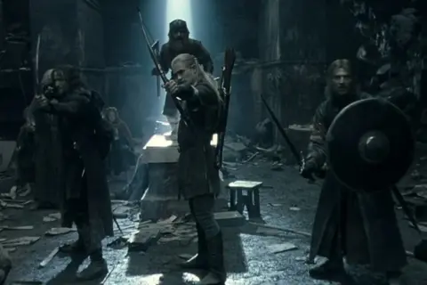 Władca Pierścieni: Drużyna Pierścienia. Elf Legolas celuje z łuku, Boromir z tarczą i mieczem gotowi do walki.