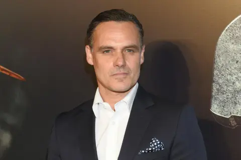 Jan Wieczorkowski, znany z imponującego wzrostu, w eleganckim garniturze i białej koszuli z granatową poszetką w kropki.