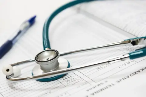 Stetoskop i długopis na dokumentach medycznych. Idealne narzędzia dla lekarza na start, gotowego do diagnozy i pomocy pacjentom.