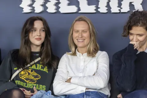 Trzy aktorki z filmu "Wielka woda" siedzą obok siebie. Jedna uśmiecha się szeroko, druga patrzy w bok, a trzecia zasłania usta dłonią.