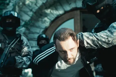 Policja zatrzymuje mężczyznę w dresie. Scena z filmu "Jak zostać gangsterem. Obsada" pokazuje brutalne starcie.