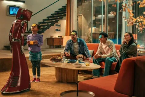 Rodzina gra w grę z robotem z serialu "Lab serial TVN". Na czołach mają karteczki z zagadkami.