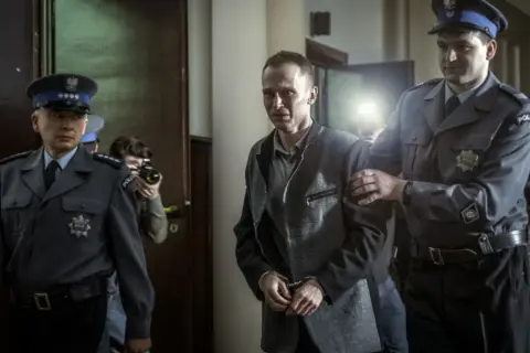 Tomek Komenda, skuty kajdankami, prowadzony przez policjantów. Historia o 25 latach niewinności.