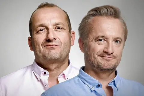 Dwóch mężczyzn, być może piękni i bezrobotni obsada, w koszulach. Jeden w różowej, drugi w błękitnej.