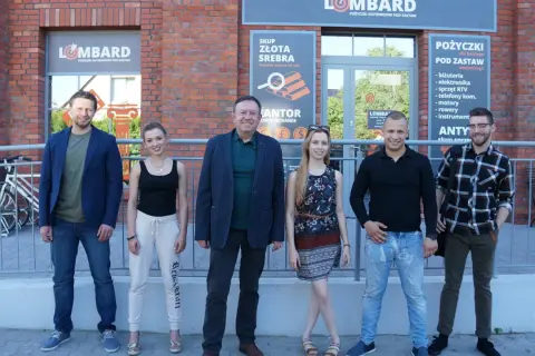 Ekipa lombardu "Życie pod zastaw" pozuje przed budynkiem.