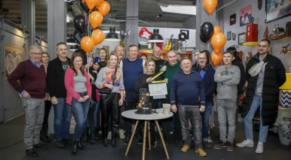 Aktorzy lombardu "Życie pod zastaw" świętują 500. odcinek. Grupa ludzi pozuje do zdjęcia z tortem i tabliczką klapsową.