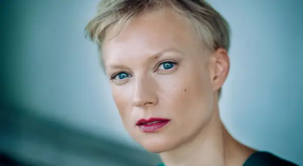 Portret Lise Risom Olsen z błękitnymi oczami i krótkimi blond włosami.