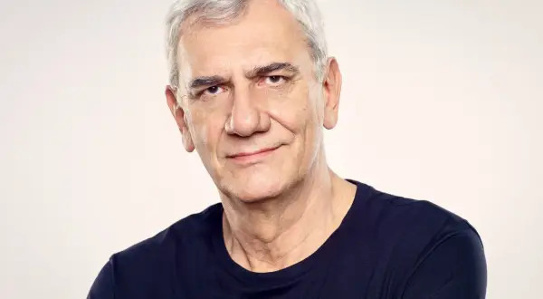 Wiktor Zborowski, z siwymi włosami i w granatowej koszulce, patrzy z uśmiechem w obiektyw.