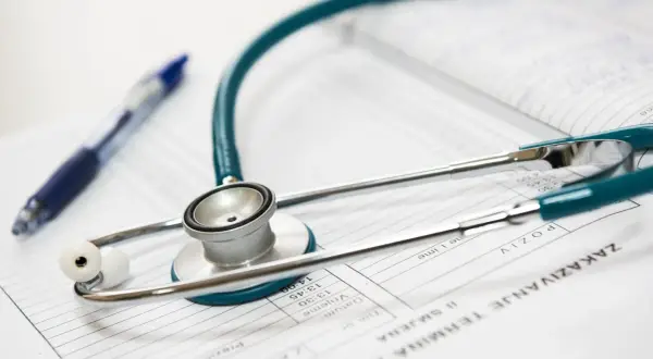 Stetoskop i długopis na dokumentach medycznych. Idealne narzędzia dla lekarza na start, gotowego do diagnozy i pomocy pacjentom.