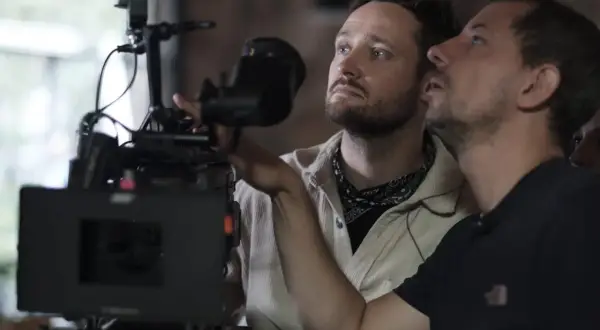 Dwóch mężczyzn przy profesjonalnej kamerze filmowej, jeden z nich reżyser Daniel Jaroszek.