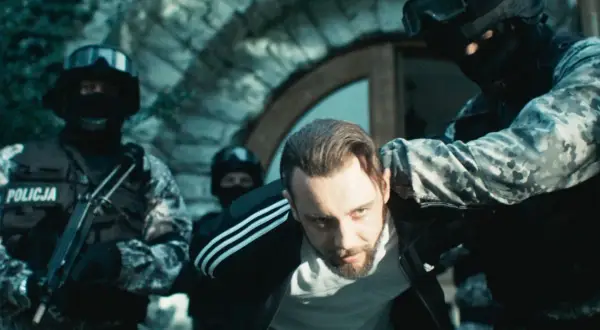 Policja zatrzymuje mężczyznę w dresie. Scena z filmu "Jak zostać gangsterem. Obsada" pokazuje brutalne starcie.