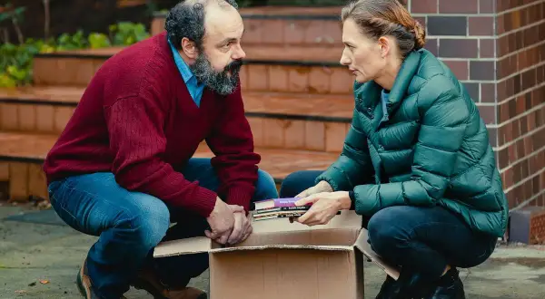 Para z kartonem książek, jakby przygotowywali się do przeprowadzki. Scena z filmu "Czarna owca".