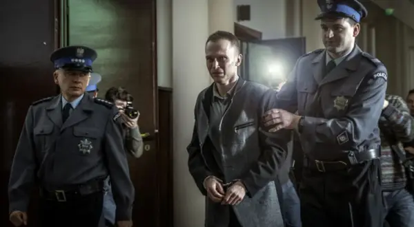 Tomek Komenda, skuty kajdankami, prowadzony przez policjantów. Historia o 25 latach niewinności.