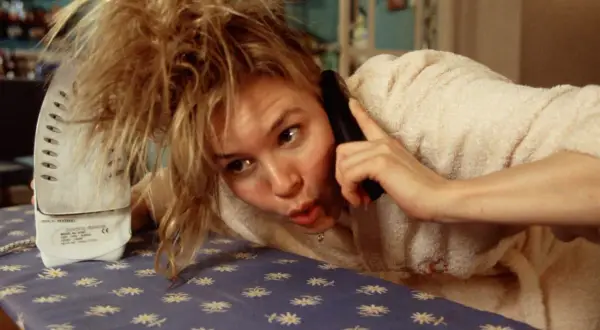 Bridget Jones w pogoni za rozumem: Renée Zellweger na desce do prasowania, rozmawiając przez telefon, z rozczochranymi włosami.