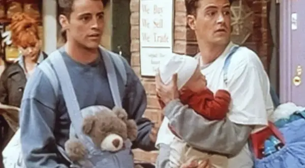 Chandler Bing z niemowlakiem i Joey z misiem w nosidle.
