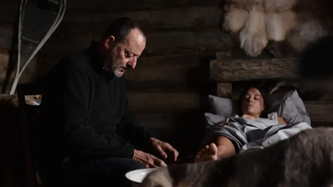 Jean Reno w "Cold Blood Legacy" obsada: mężczyzna pochyla się nad ranną kobietą w chatce.