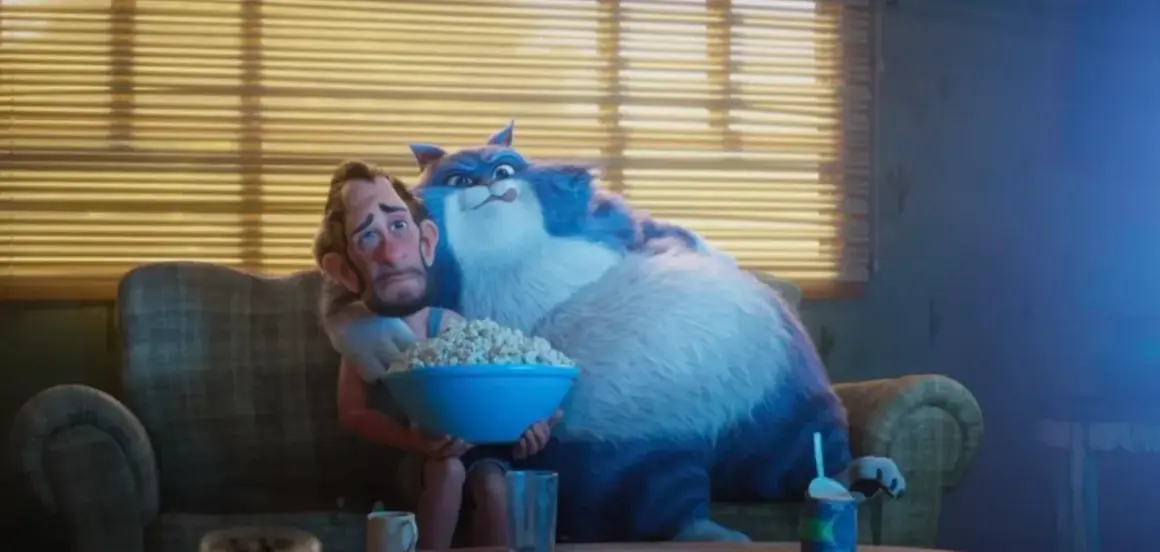Wielki, niebieski kot przytula zmartwionego mężczyznę, który trzyma miskę popcornu. To scena z filmu "Jak pies z kotem", gdzie relacje między zwierzętami a ludźmi bywają skomplikowane.