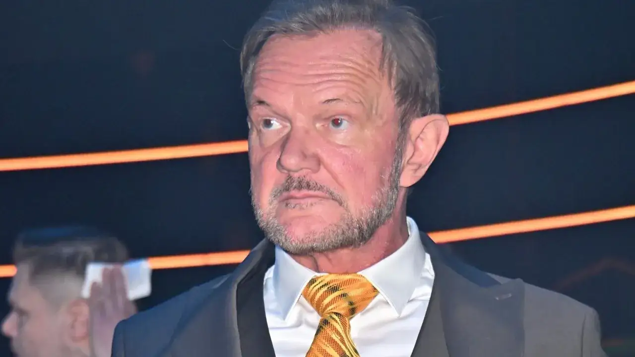 Cezary Pazura w garniturze i krawacie, z zaciekawieniem spogląda w bok. Ciekawe, ile zarabia Cezary Pazura, myśląc o karierze.