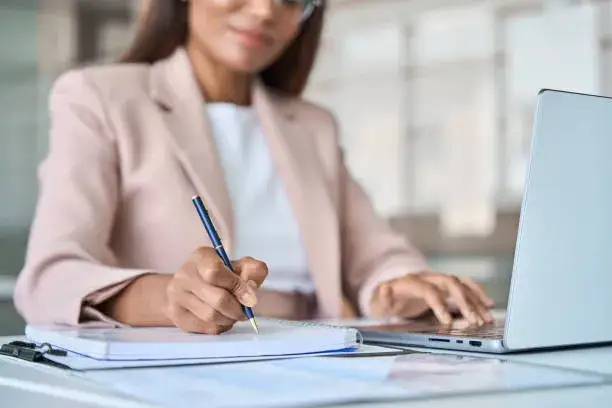 osoba podpisująca dokumenty na tle profesjonalnego biura