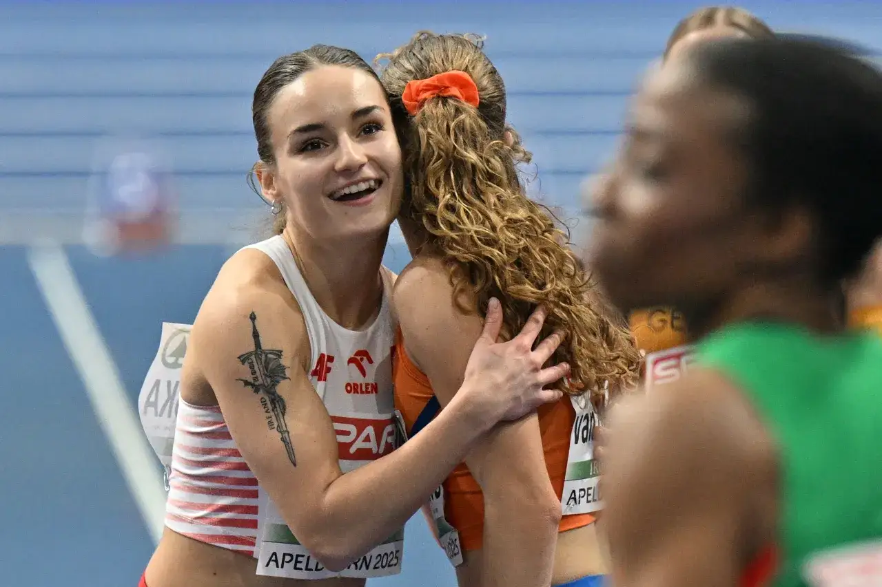 Uśmiechnięta Aleksandra Piotrowska, lekkoatletka z tatuażem miecza, przytula koleżankę po zawodach.