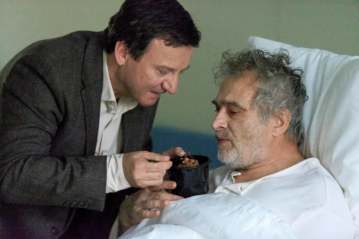 Colin Firth karmi chorego przyjaciela, jak pies z kotem obsada w scenie pełnej emocji.