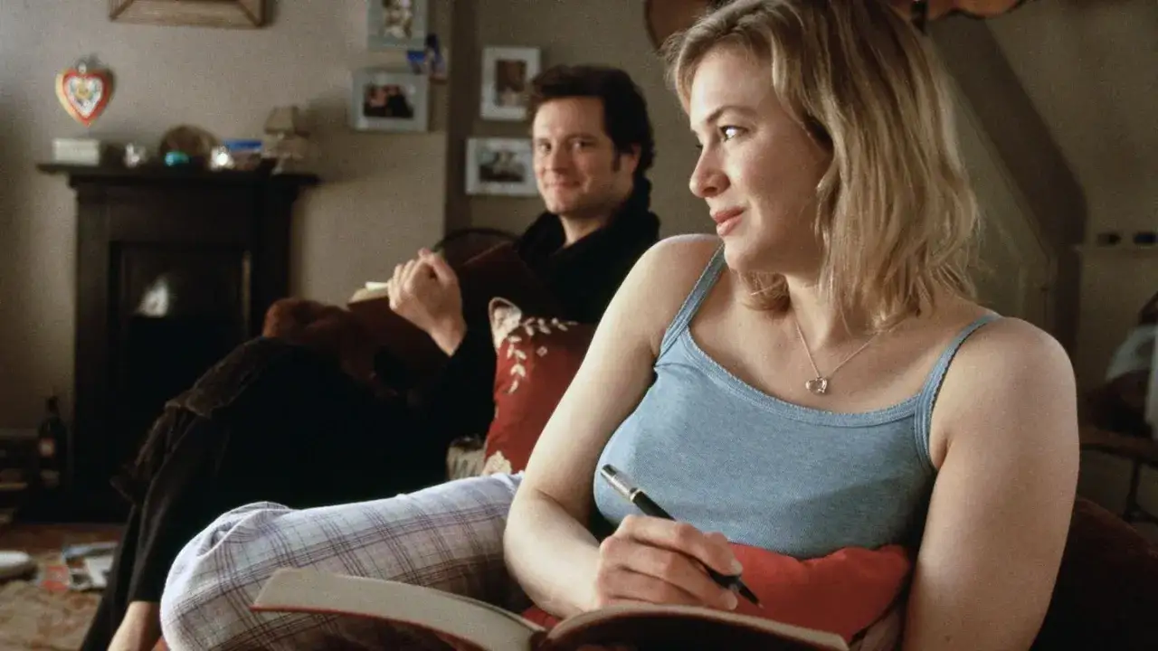 Bridget Jones w pogoni za rozumem: Renée Zellweger pisze w dzienniku, Colin Firth patrzy z uśmiechem.