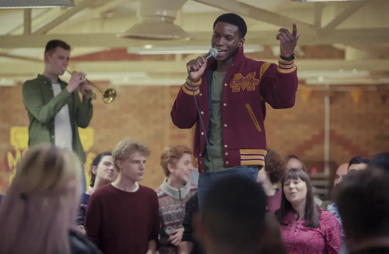 Kedar Williams Stirling śpiewa do mikrofonu w kurtce 