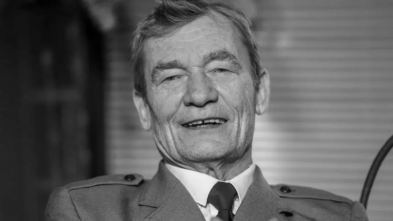 Uśmiechnięty Krzysztof Kiersznowski w garniturze, z charakterystycznym spojrzeniem.