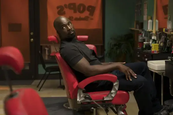 Luke Cage obsada: Mike Colter w czerwonym fotelu fryzjerskim, w tle szyld "Pop's Barber Shop".