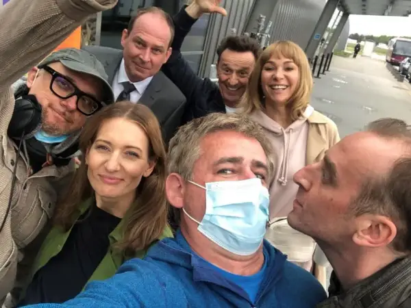Uśmiechnięta usta usta obsada na planie zdjęciowym. Wszyscy w dobrych humorach, gotowi do pracy.
