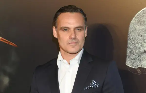 Jan Wieczorkowski, znany z imponującego wzrostu, w eleganckim garniturze i białej koszuli z granatową poszetką w kropki.
