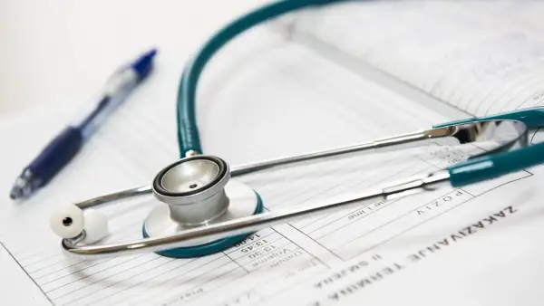 Stetoskop i długopis na dokumentach medycznych. Idealne narzędzia dla lekarza na start, gotowego do diagnozy i pomocy pacjentom.