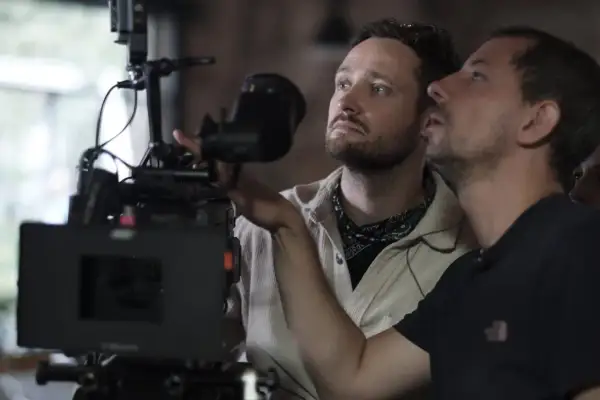 Dwóch mężczyzn przy profesjonalnej kamerze filmowej, jeden z nich reżyser Daniel Jaroszek.